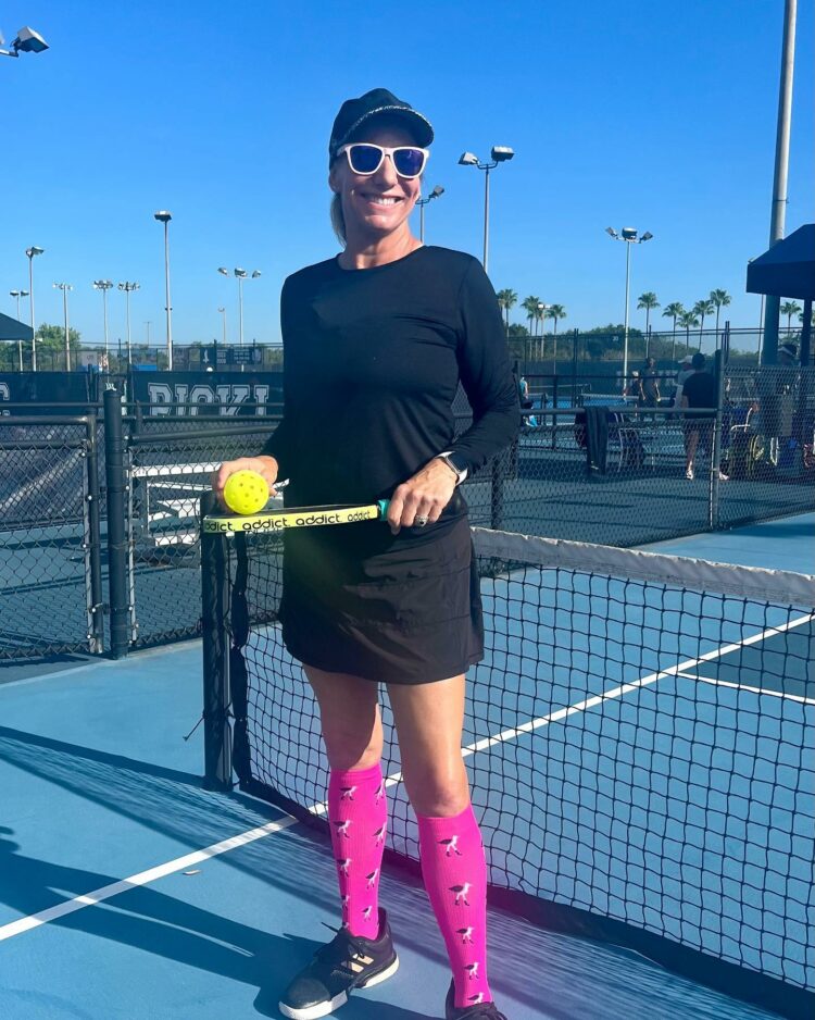 woman on the pickleball court wearing pink lily trotters over the calf compression socks