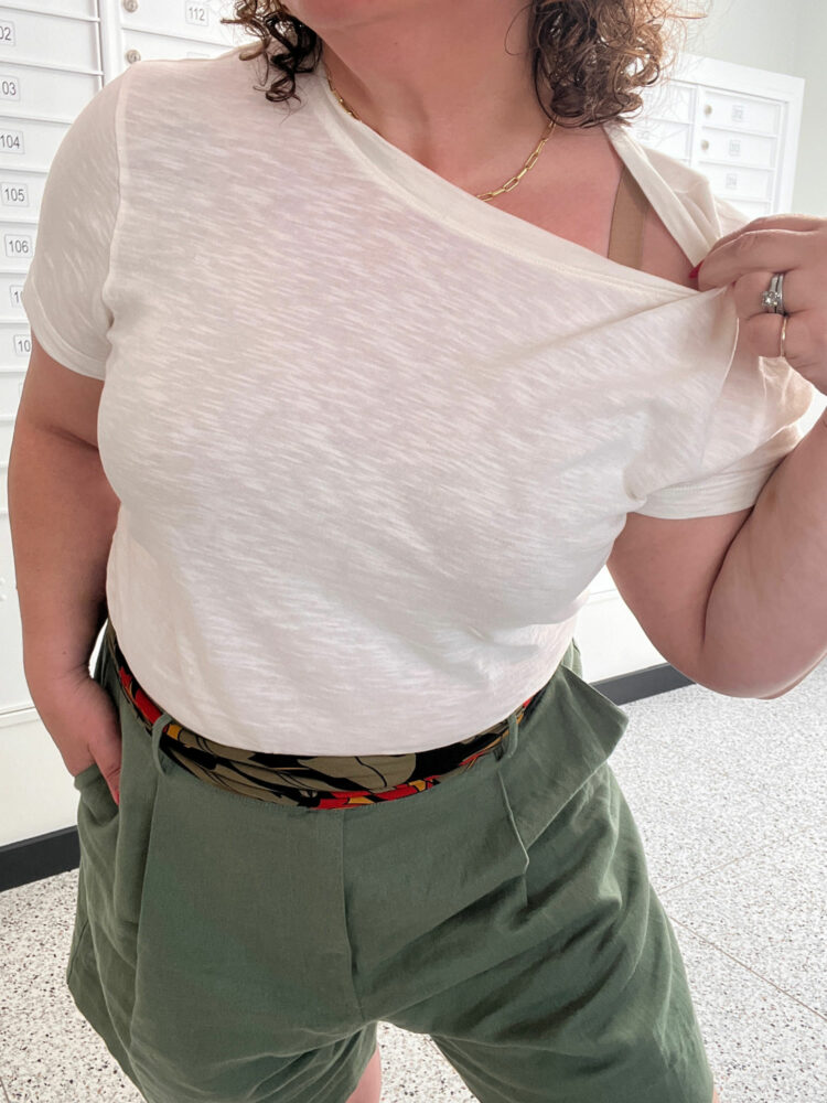 Alison of Wardrobe Oxygen wearing the ABLE classic tee, pulling the neck to the side to show her bra strap and how the bra doesn't show through the slub fabric