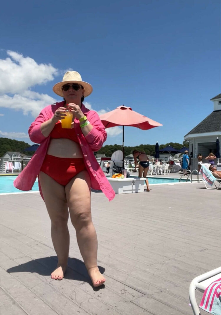 Alison in a red universal standard bikini, pink Lands' End linen tunic, and straw hat