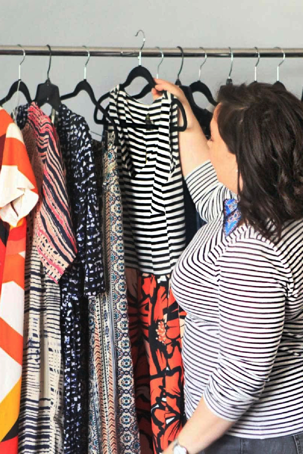 Alison Gary of Wardrobe Oxygen pulling a striped dress from her closet