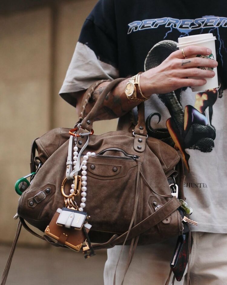 a vintage balenciaga city bag in brown leather decorated with bag charms and beads