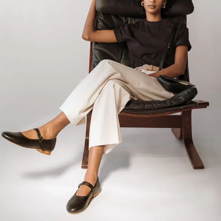 The Poppy Barley Modern-Day Mary Jane on a woman in ivory trousers and a black t-shirt, sitting in a leather chair