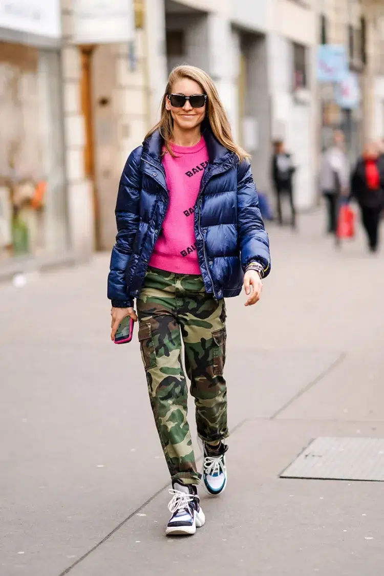 woman in camo pants with a hot pink sweatshirt and shiny blue puffer jacket