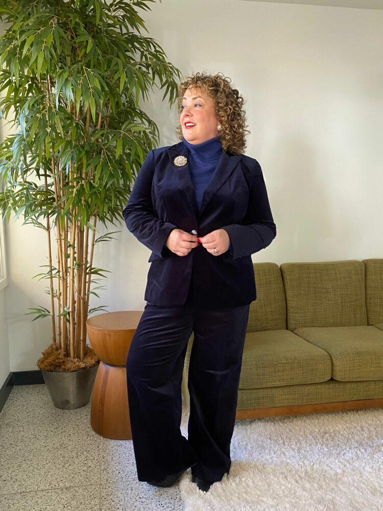 Alison Gary of Wardrobe Oxygen in a navy velveteen pantsuit from Talbots with a Talbots blue cashmere turtleneck and a brooch on the jacket lapel