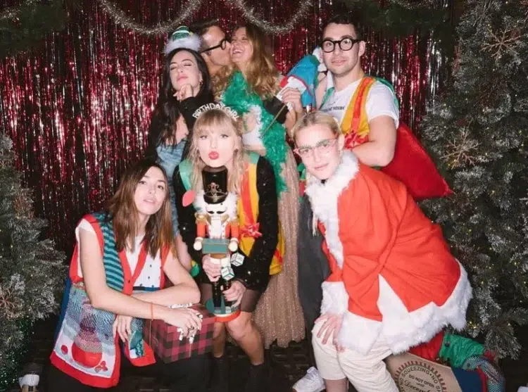 Taylor Swift and friends in 2019 wearing ugly Christmas sweaters