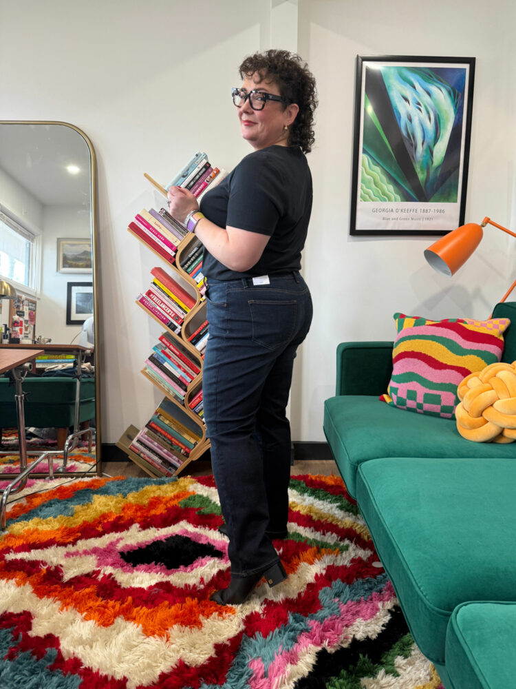 Alison Gary of Wardrobe Oxygen in her office wearing Talbots Straight Leg jeans and a black short-sleeved t-shirt